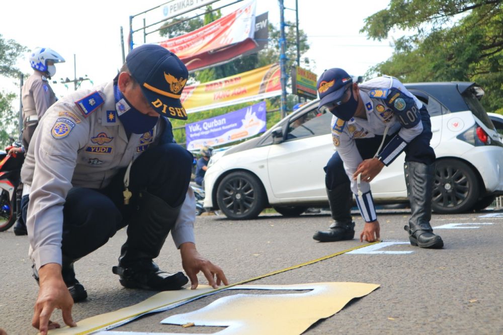 Petugas membuat garis bagi pengendara motor di Ponorogo
