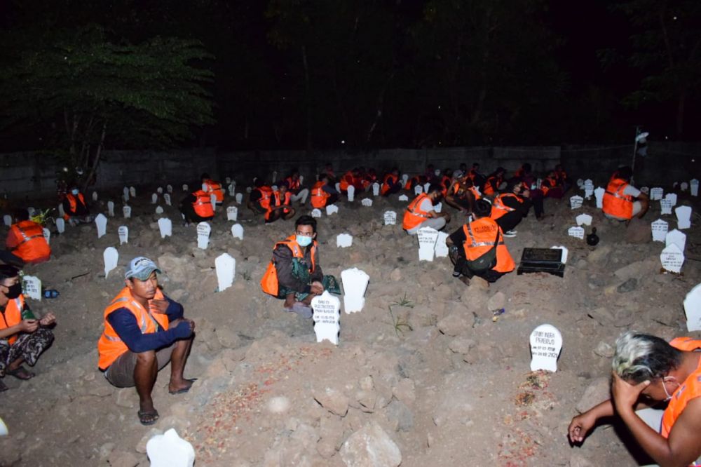 Pelanggar terjarian razia protokol kesehatan berdoa di makam korban Covid-19