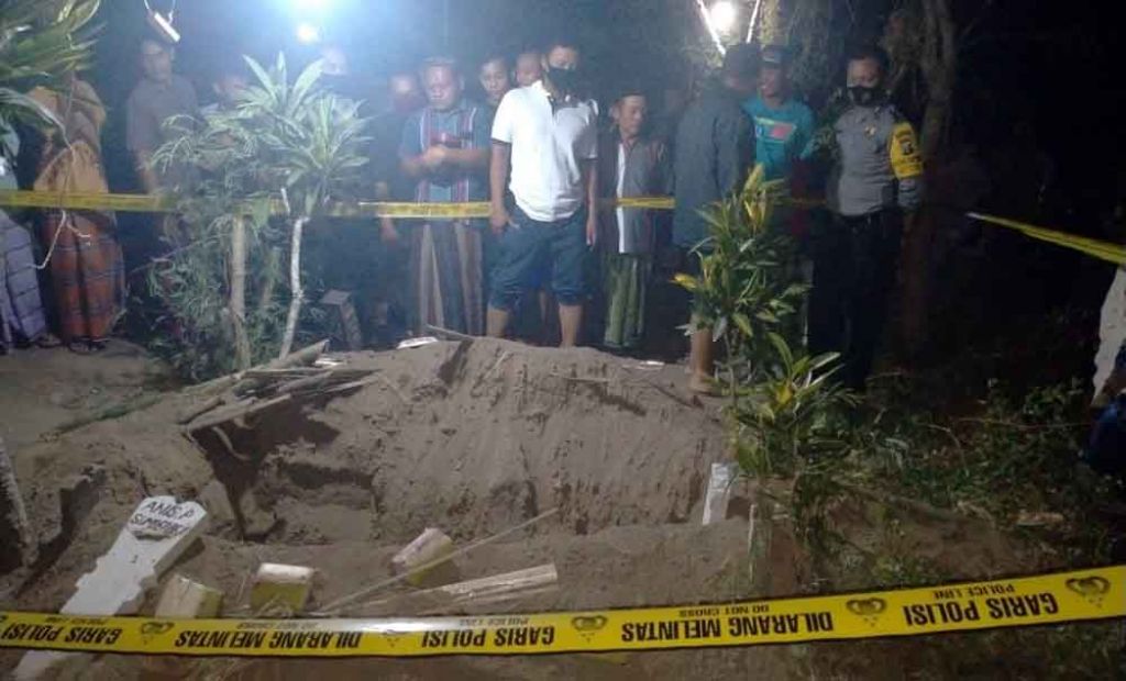 Polisi melakukan olah tkp di makam yang dibongkar dan kain kafannya hilang
