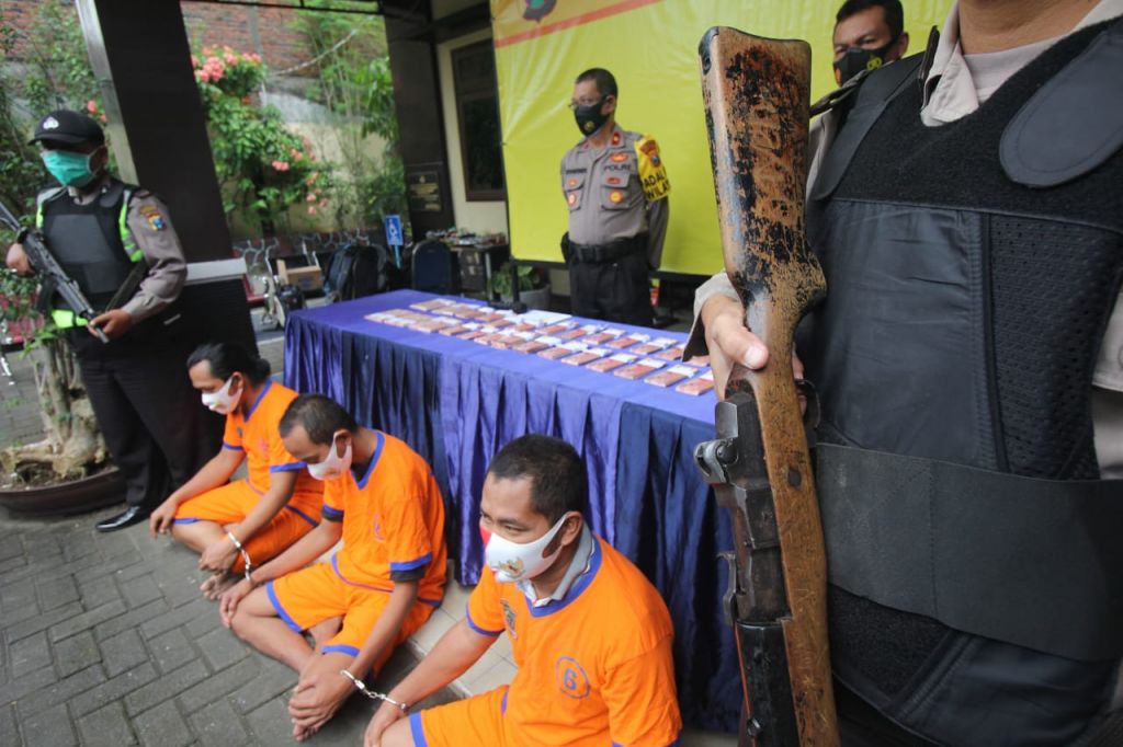Tersangka dan barang bukti uang palsu dipamerkan di Mapolsek Jambangan, Surabaya
