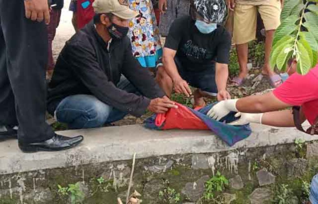 Polisi dan warga mengevakuasi mayat bayi laki yang ditemukan di sungai