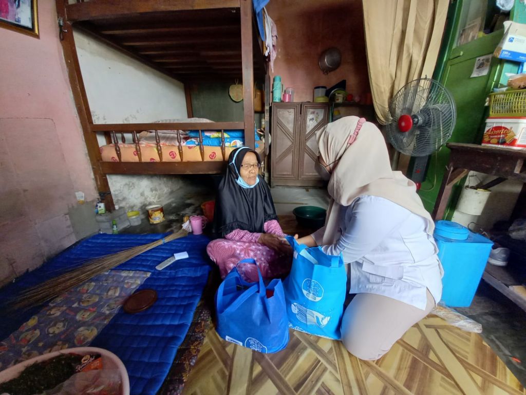 Nenek Sumirah mendapatkan bantuan sembako di rumahnya di kawasan Simojawar, Surabaya.