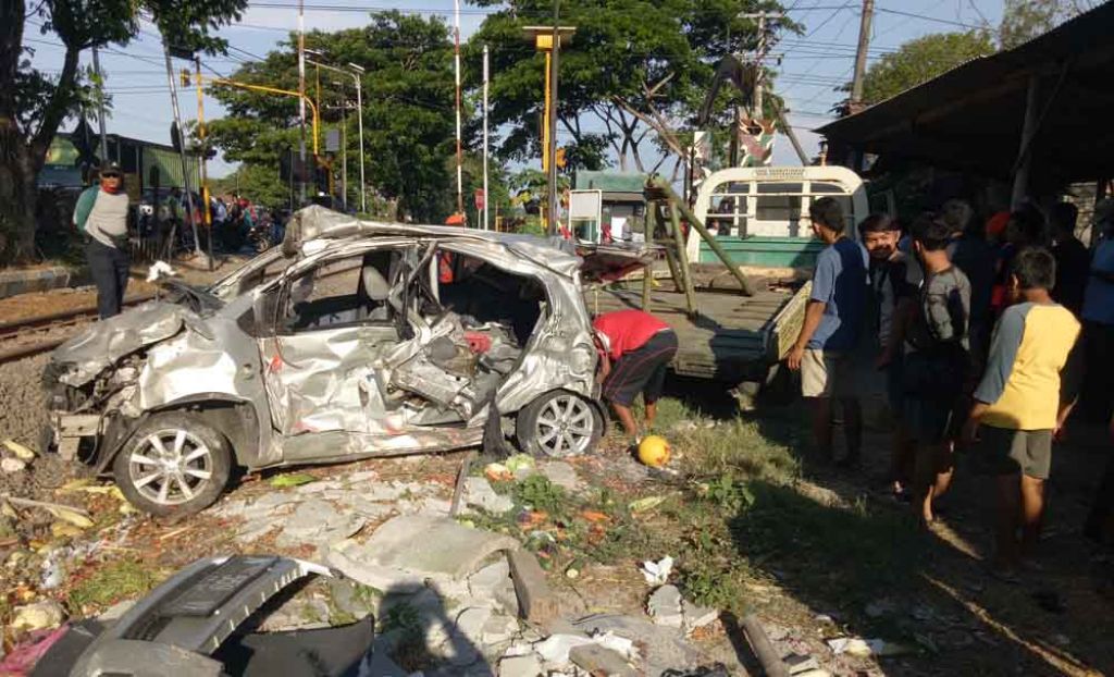 Mobil yang ringsek dievakuasi petugas 
