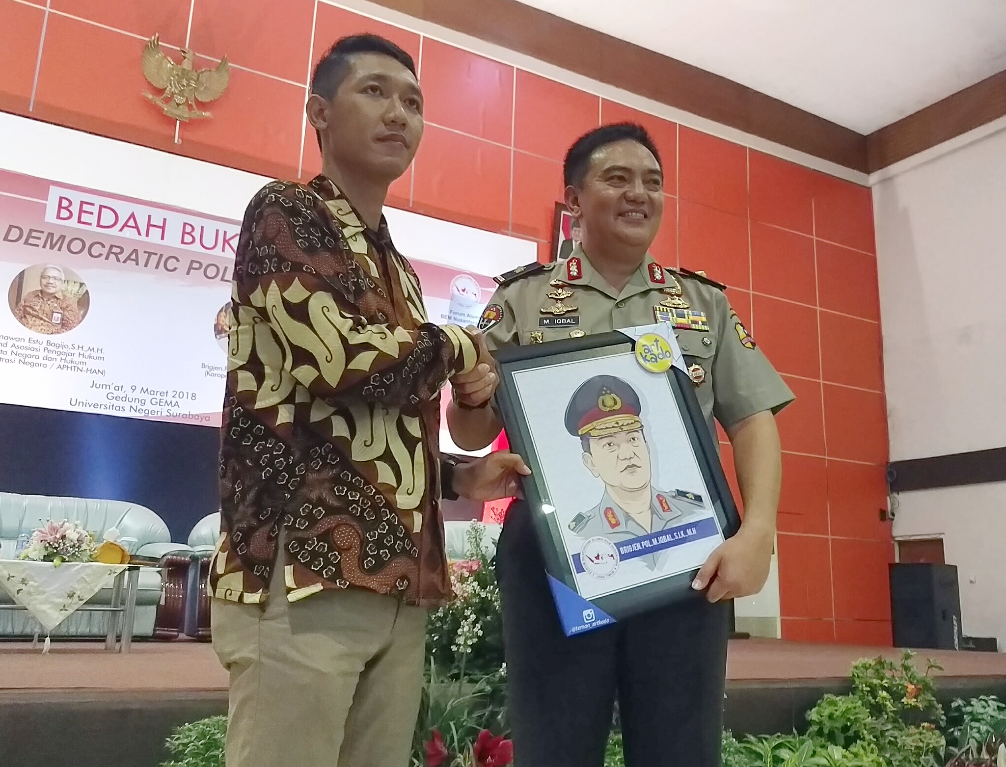 Brigjen Pol M Iqbal S.I.K MH, Karopenmas Mabes Polri, menerima karikatur dirinya dari civitas akademik.