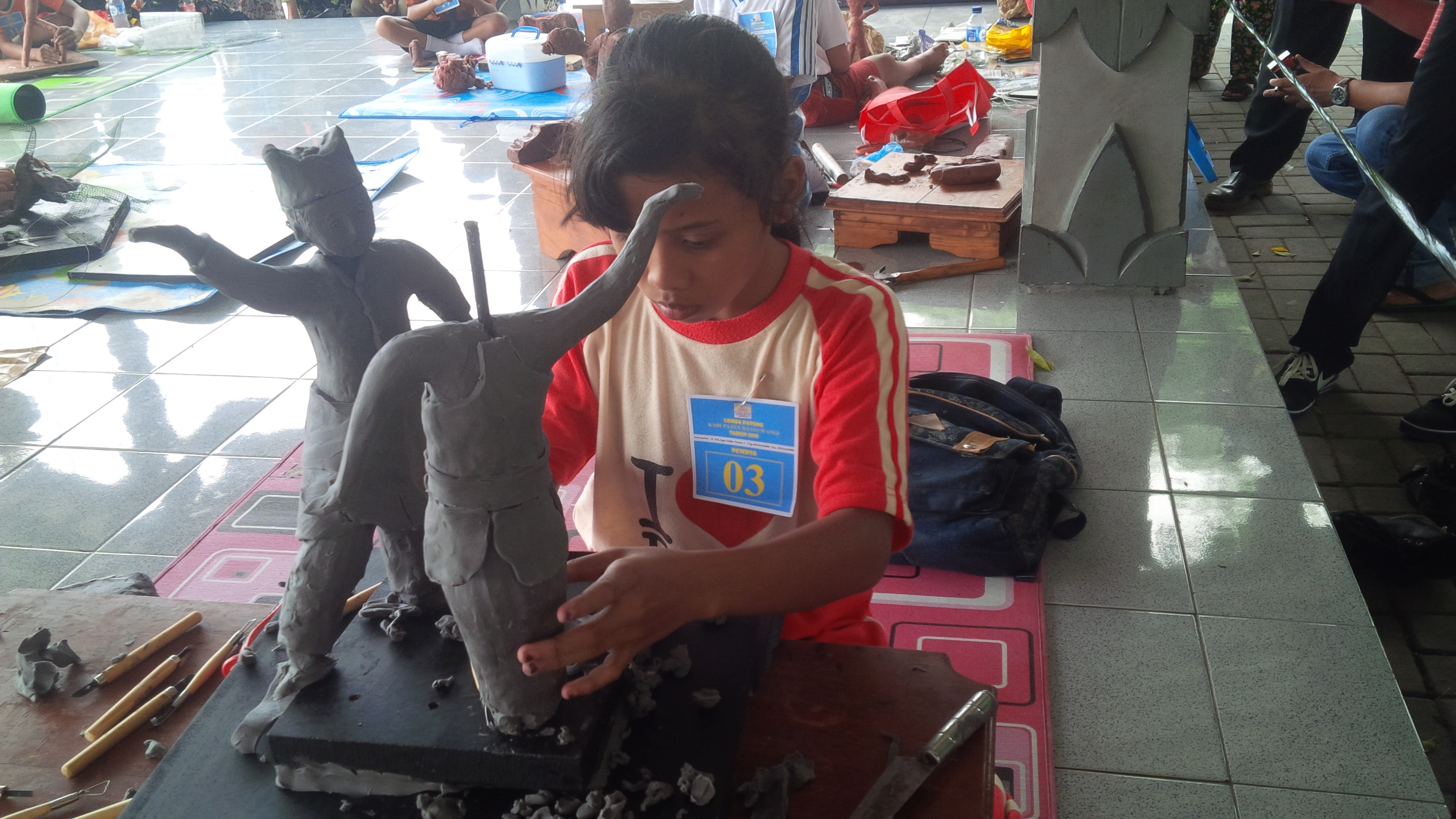 Dwi Safirna (11) saat membuat sepasang patung Penari Gandrung.
