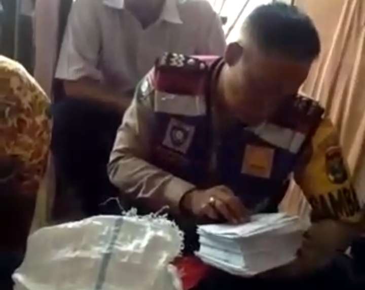 Petugas kepolisian memeriksa karung yang berisi Kartu Indonesia Pintar. 