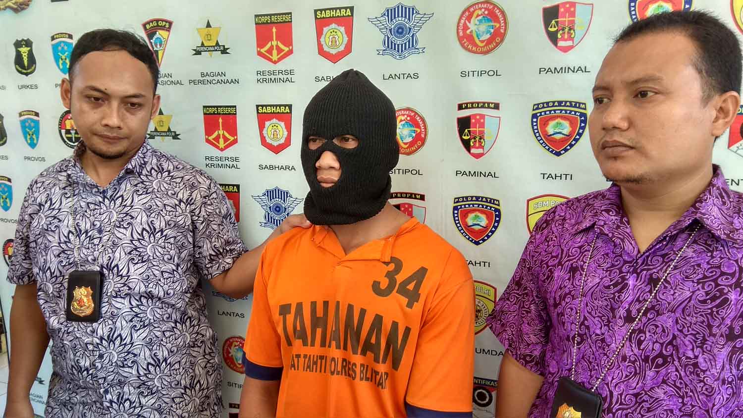 Tersangka diapit petugas.