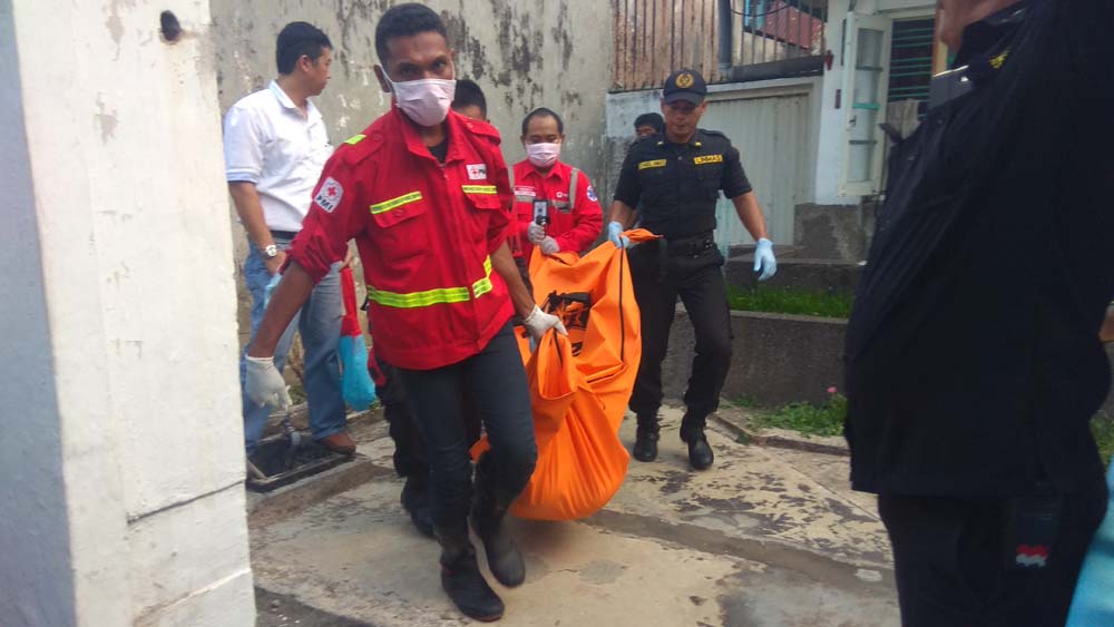 Petugas melakukan evakuasi jenazah Lie Cyong