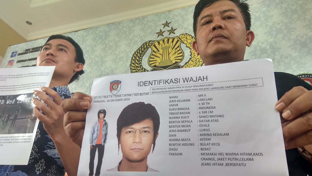 Petugas menunjukkan sketsa wajah pelaku