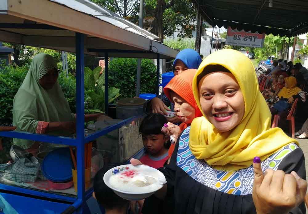Warga mendapatkan es dawet secara gratis usai coblos ulang