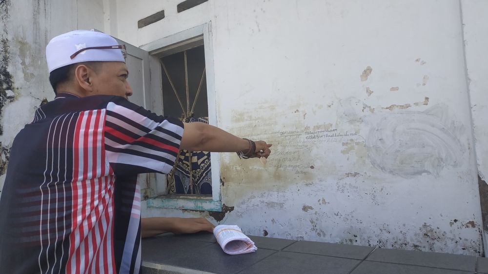Warga menunjukkan  jejak tulisan tangan Sugeng di Jodipan Wetan, Kota Malang 