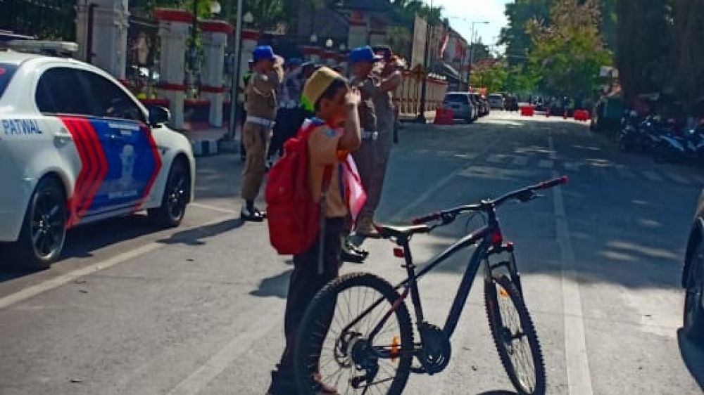 Viral di Medsos, Foto Siswa SD Turun dari Sepeda dan Hormat Bendera