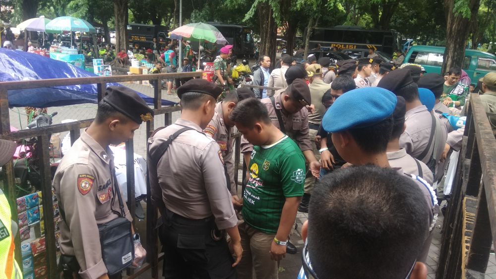 Polisi memeriksa barang milik suporter sebelum masuk ke dalam Stadion Gelora Delta Sidoarjo