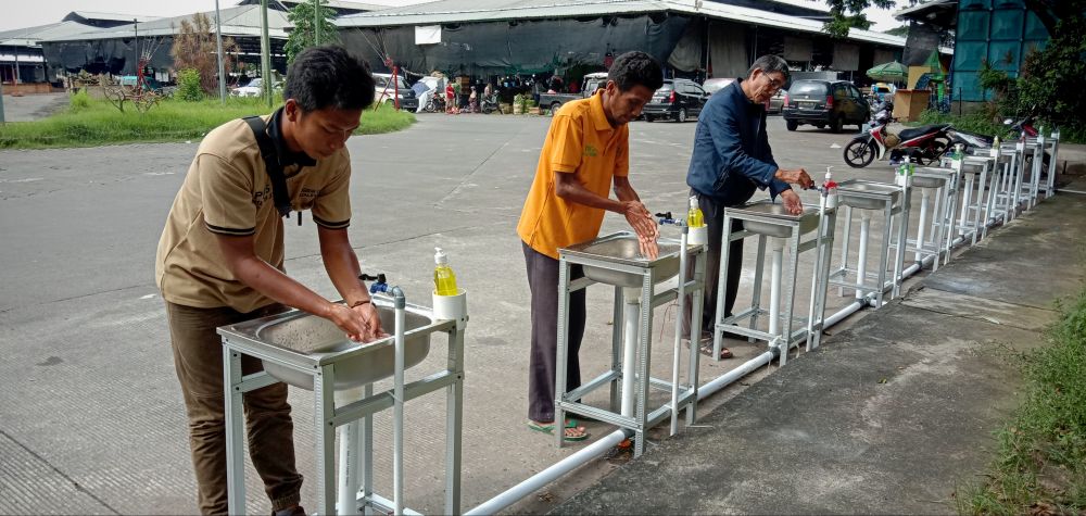 Pedagang dan pengunjung di PIOS mencuci tangan untuk mencegah penyebaran Virus Corona