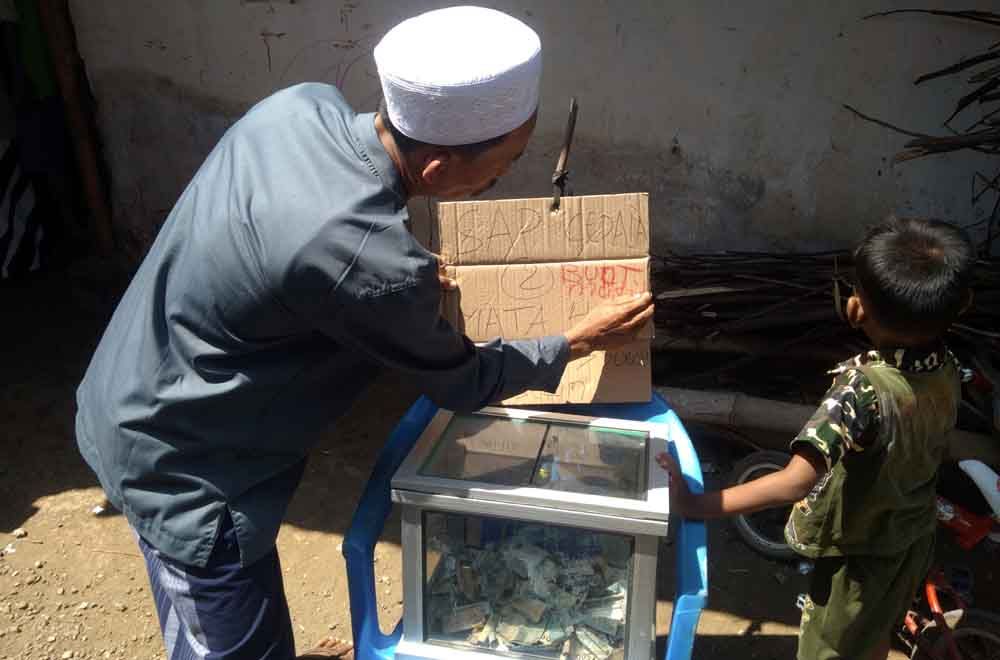 Pemilik anak sapi memasang kotak amal bagi warga 