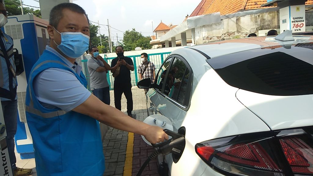 Komisaris PT PLN Dudy Purwagandhy saat mengisi bahan listrik di mobil listrik yang dikendarainya di SPKLU Jalan dr Soetomo, Surabaya