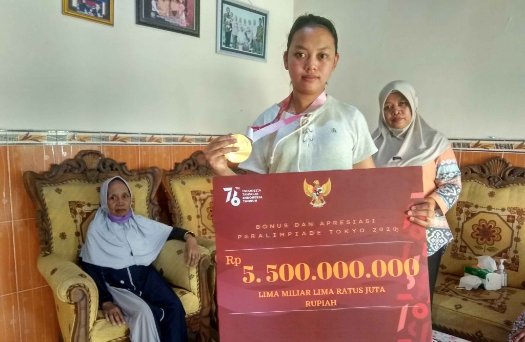 Khalimatus Sadiyah memamerkan medali emas Paralimpiade Tokyo 2020.