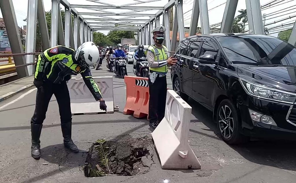 Anggota Satlantas Polres Pasuruan menunjukkan titik yang ambles di Jembatan Kedunglarangan