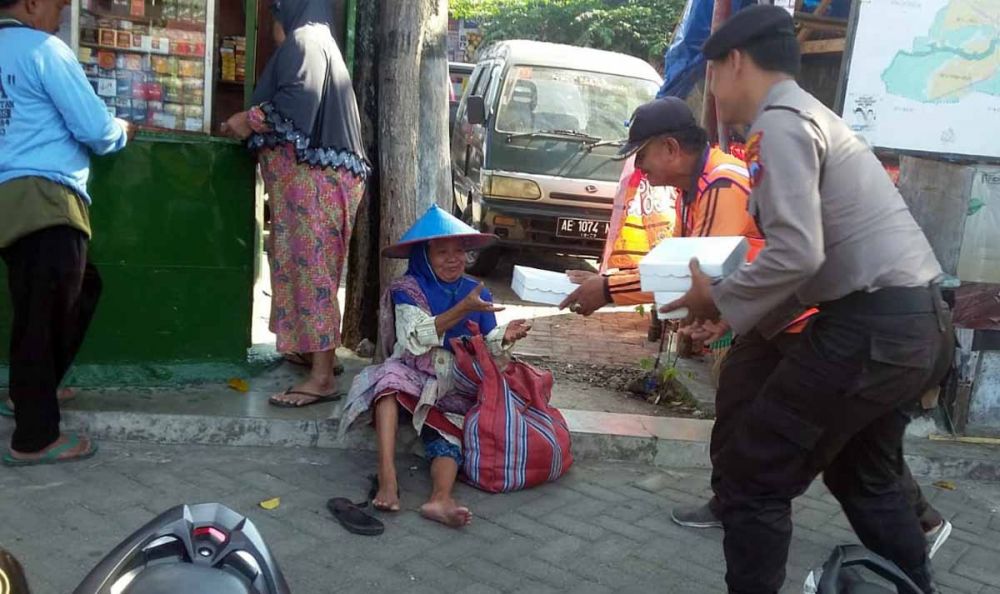 Anggota Polres Magetan melaksanakan program Jumat Berkah dengan membagikan nasi kotak