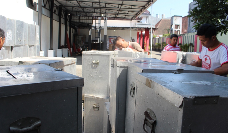 Petugas membersihkan bilik dan kota suara untuk persiapan Pilgub Jatim.