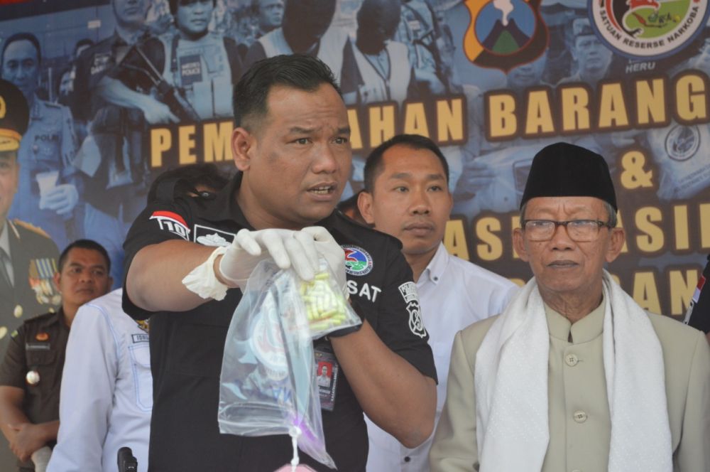 Kasat Resnarkoba Polrestabes Surabaya Kompol Memo Ardian menunjukkan pil ekstasi yang disita dari para pengedar, 91 di antaranya ekstasi yang dikemas dalam kapsul