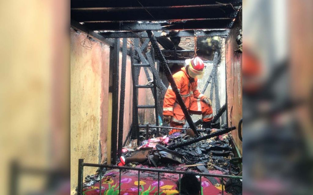 Petugas pemadam kebakaran melakukan pembasahan di lokasi