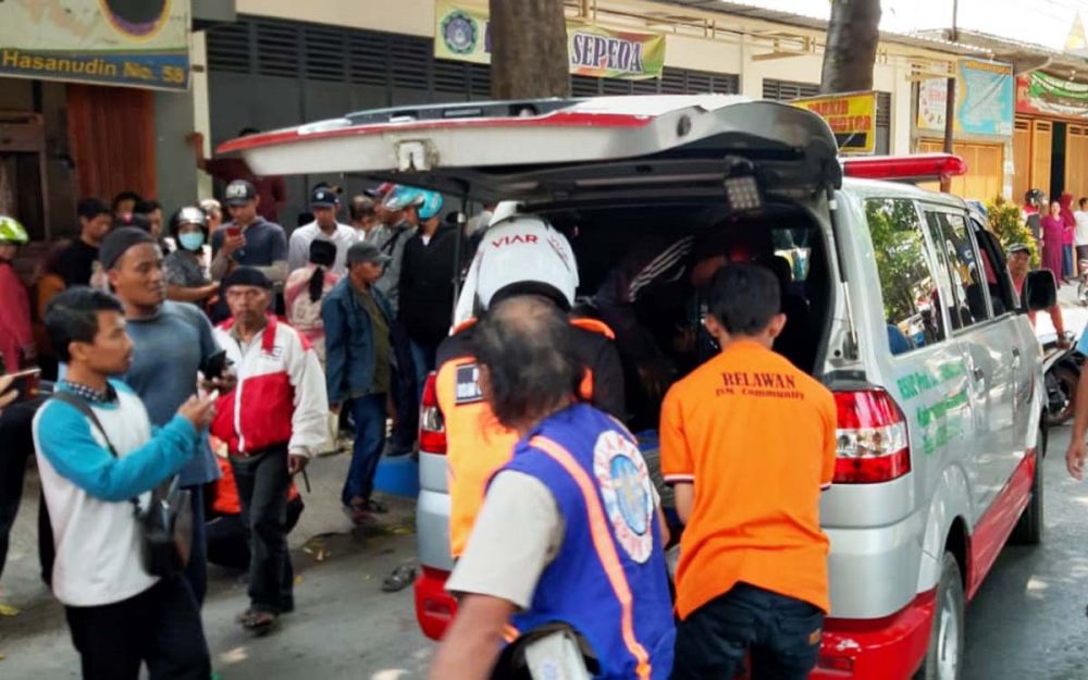 Petugas mengevakuasi jasad suami istri yang tewas terlindas ban truk gandeng di Mojosari, Mojokerto