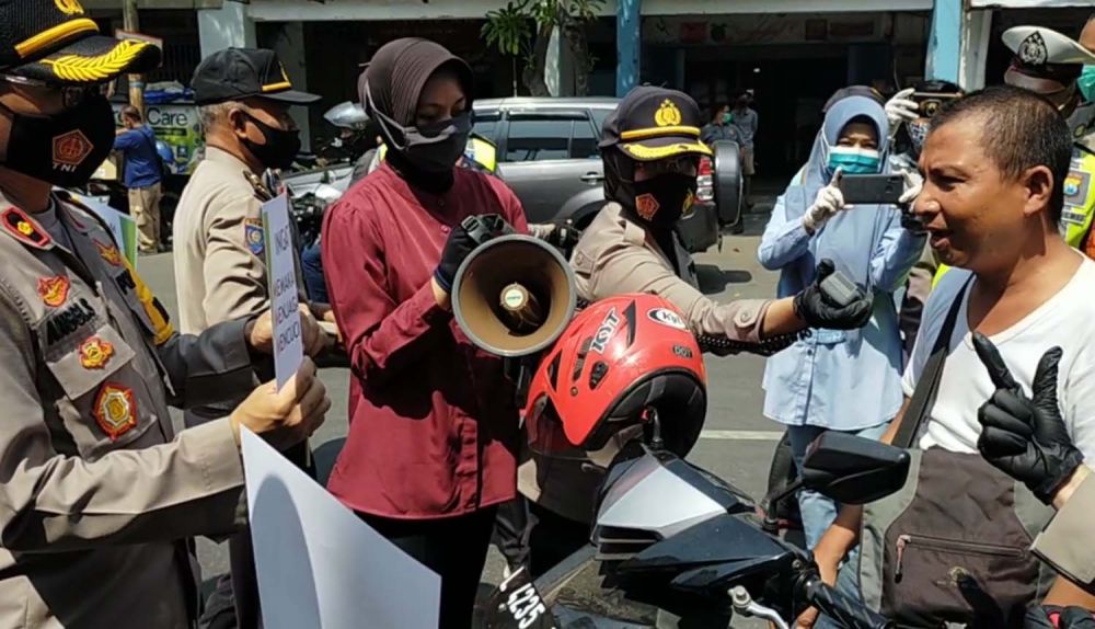 Kapolres Pelabuhan Tanjung Perak AKBP Ganis Setyaningrum membagikan masker untuk pengguna jalan di Surabaya