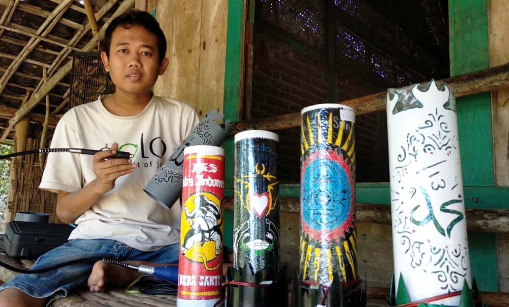 Suwandi, difabel asal Ngawi sedang mengerjakan karya lampu hias dari paralon bekas