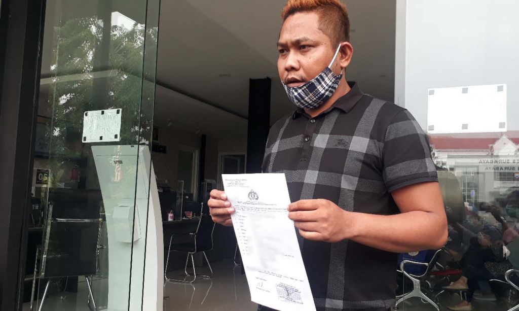 Ketua KIPP Jatim, Novli Bernado Thyssen menunjukkan surat laporan polisi yang dibuatnya