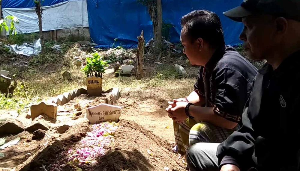 Keluarga berdoa di makam Nanang Subiyanto, Ketua KPPS di Banyuwangi yang meninggal dunia
