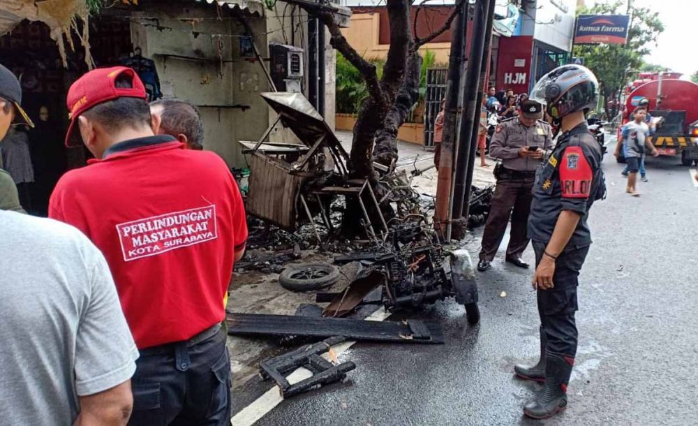 Petugas mendatangi lokasi kecelakaan yang menyebabkan kebakaran kios bensin di Jalan Kenjeran, Surabaya