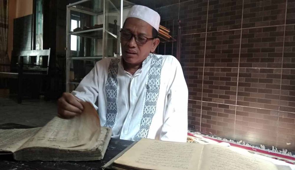 Pengasuh Ponpes As Sholichiyah, Kiai Muhammad Rofi'i menunjukkan salah satu koleksi kitab tua