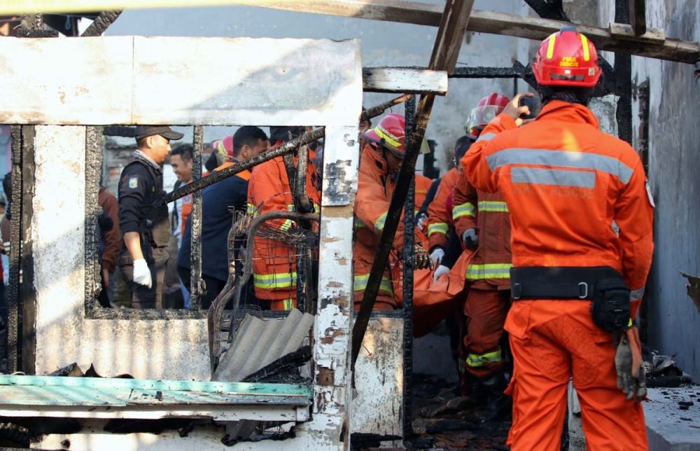 Petugas mengevakuasi jasad korban kebakaran di Kenjeran, Surabaya