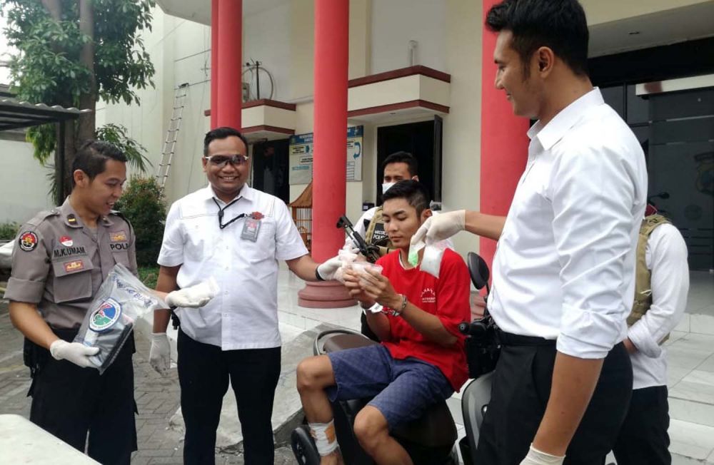 Kasatresnarkoba Polrestabes Surabaya Kompol Memo Ardian (dua dari kiri) menunjukkan kurir yang ditembak dan barang bukti ekstasi dan sabu