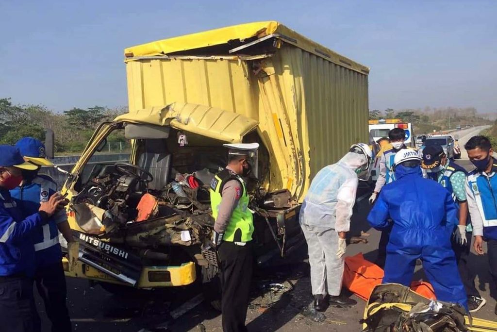 Petugas mengevakuasi jenazah salah satu penumpang truk boks yang mengalami kecelakaan di Tol Madiun-Nganjuk