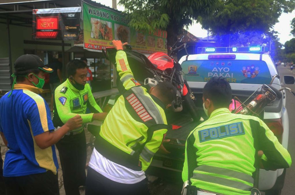 Anggota Unit Laka Satlantas Polres Ponorogo mengevakuasi sepeda dan motor yang terlibat tabrakan