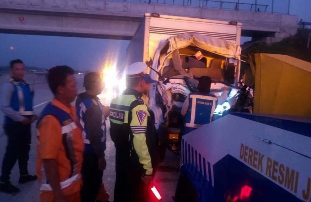 Petugas mengevakuasi truk boks yang menabrak truk tronton di Tol Madiun-Kertosono