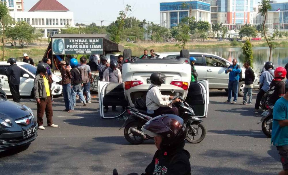 Mitsubishi Outlander terbalik di tepi danau Jalan Babatan Unesa, Surabaya (foto: Istimewa)