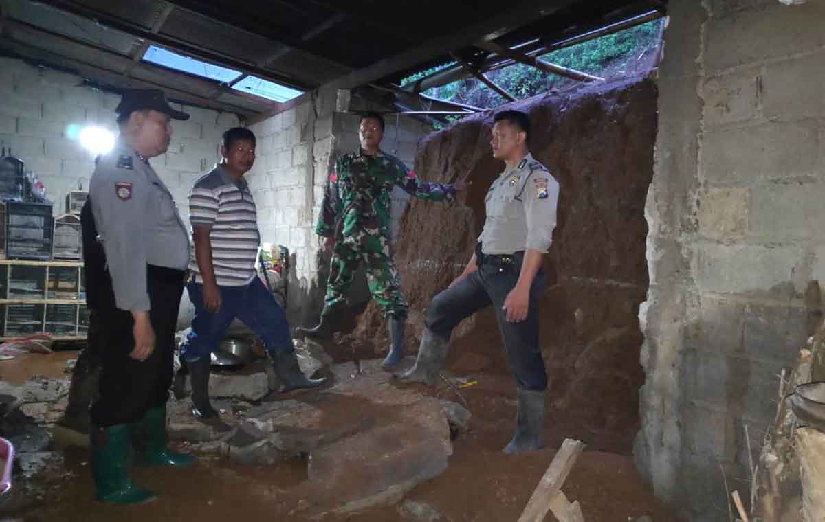 Petugas gabungan mengecek kondisi rumah yang tertimpa longsor di Ponorogo