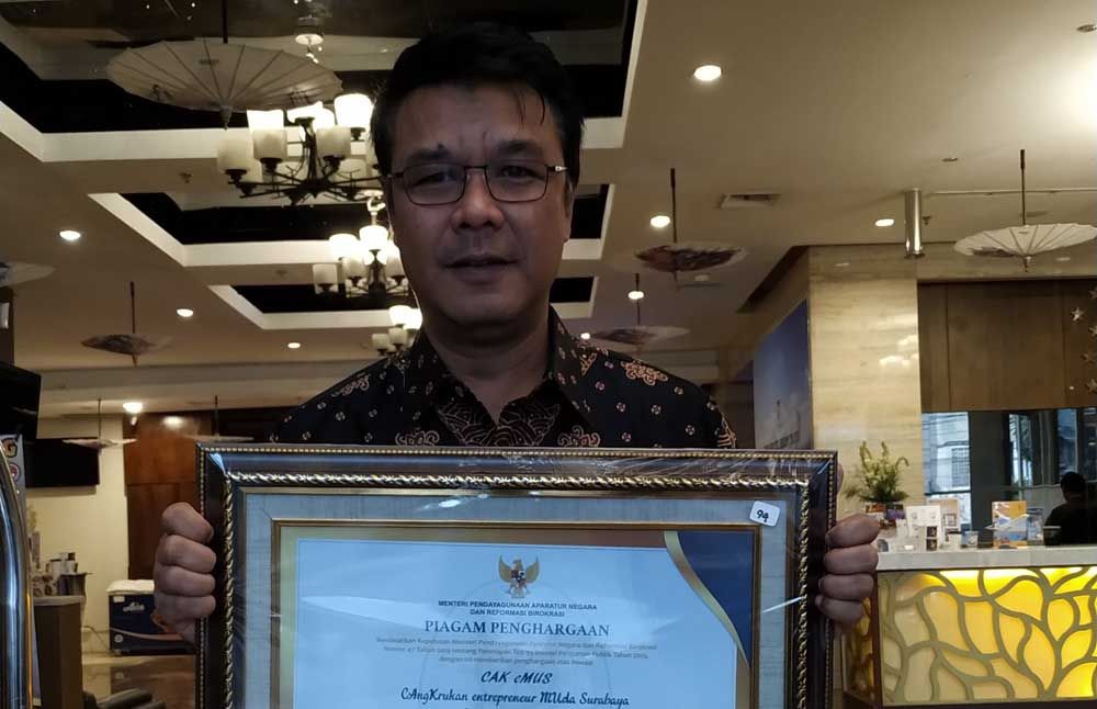 M Fikser tunjukkan penghargaan yang diterima Pemkot Surabaya