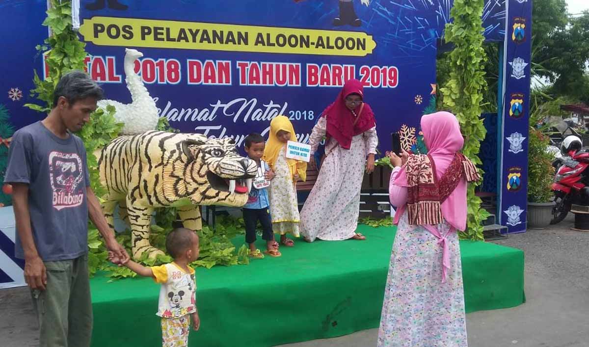 Warga berfoto bersama dengan harimau replika di pos pam milik Polres Ponorogo
