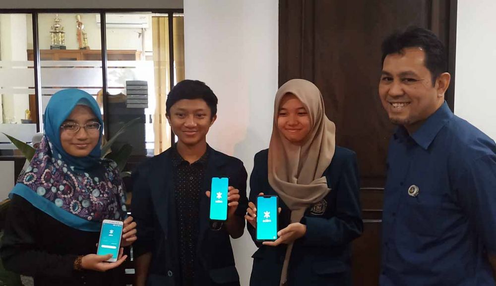 Tiga mahasiswa UB dan dosen pembimbing menunjukkan Aplikasi Adem ciptaan mereka