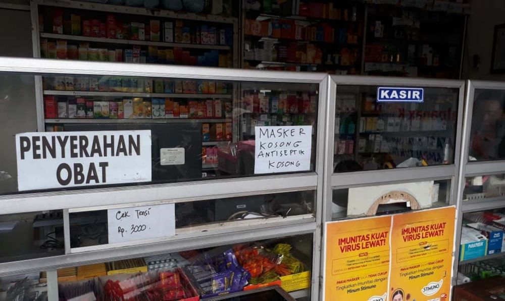 Salah satu apotek di Surabaya memasang pengumuman kalau masker dan antiseptik kosong (Foto: Zain Ahmad/jatimnow.com)