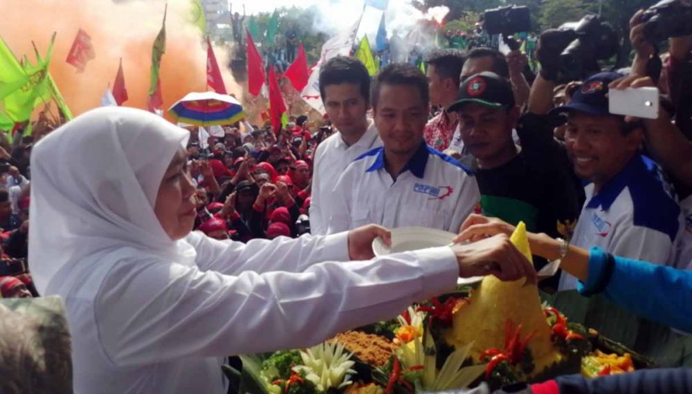 Gubernur Jatim Khofifah Indar Parawansa memberikan potongan tumpeng kepada perwakilan buruh saat peringatan May Day 2019