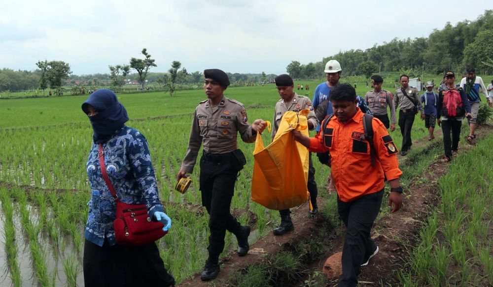 Petugas mengevakuasi mayat bayi yang ditemukan dalam saluran irigasi di Ponorogo