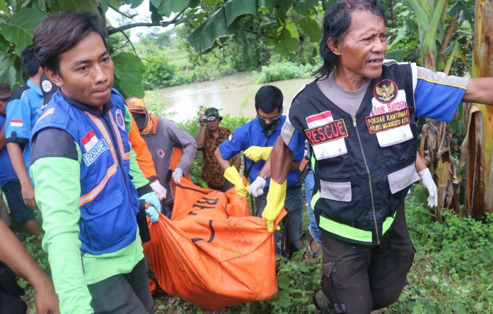 Petugas mengevakuasi mayat perempuan dari sungai