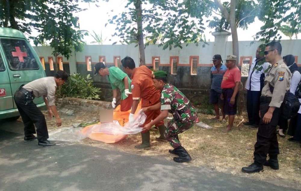 Petugas  mengevakuasi mayat pria misterius yang ditemukan di selokan Pasar Tepas Geneng, Ngawi