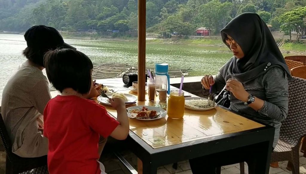 Pengunjung mencicipi ketan durian sambil menikmati keindahan Telaga Ngebel, Ponorogo