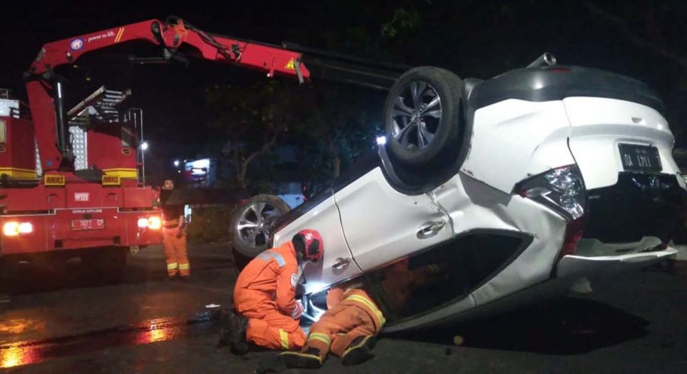 Proses evakuasi mobil Honda CRV yang terbalik oleh Unit Rescue Dinas Pemadam Kebakaran Kota Surabaya